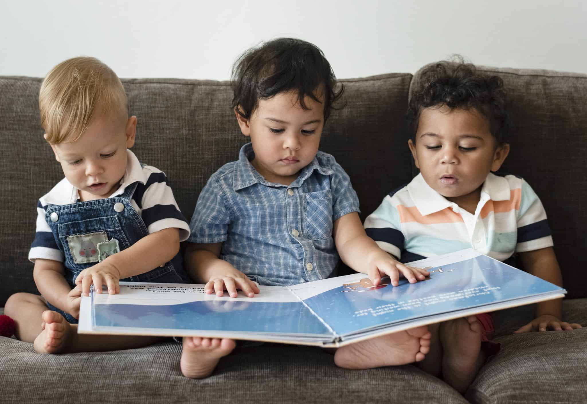 שלושה ילדים בנים קוראים בספר